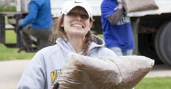 UFG employee carrying mulch while volunteering