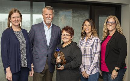GoBeyond-AgentWinner-2021-KellyThomas2 Kelly Thomas stands – silver and blue trophy in hand – between UFG’s Alison Kaster and Randy Ramlo on the left and nominators Vicky Wieditz and Erica Bergfeld-Reed on the right.