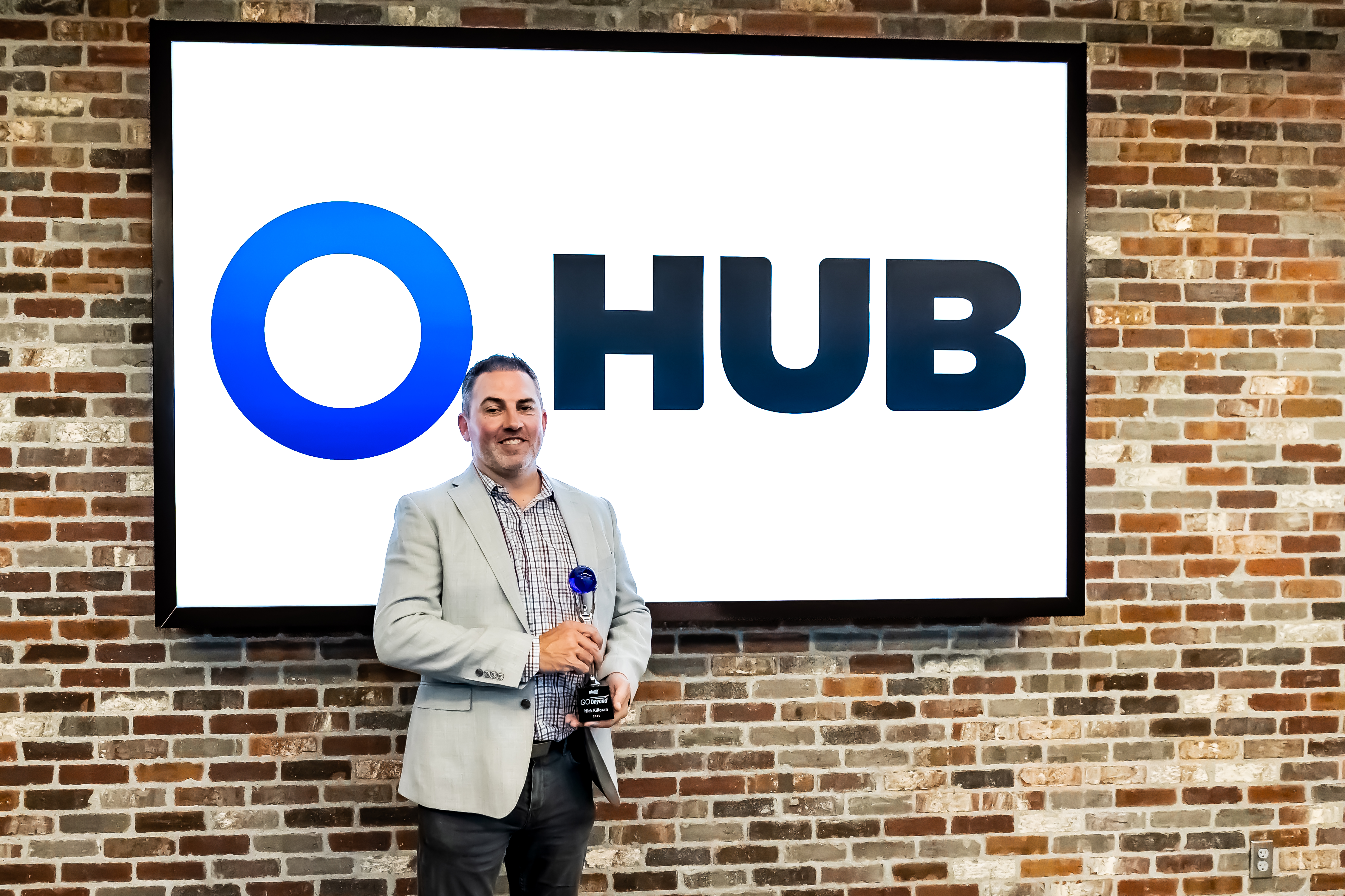 Man smiling holding trophy.