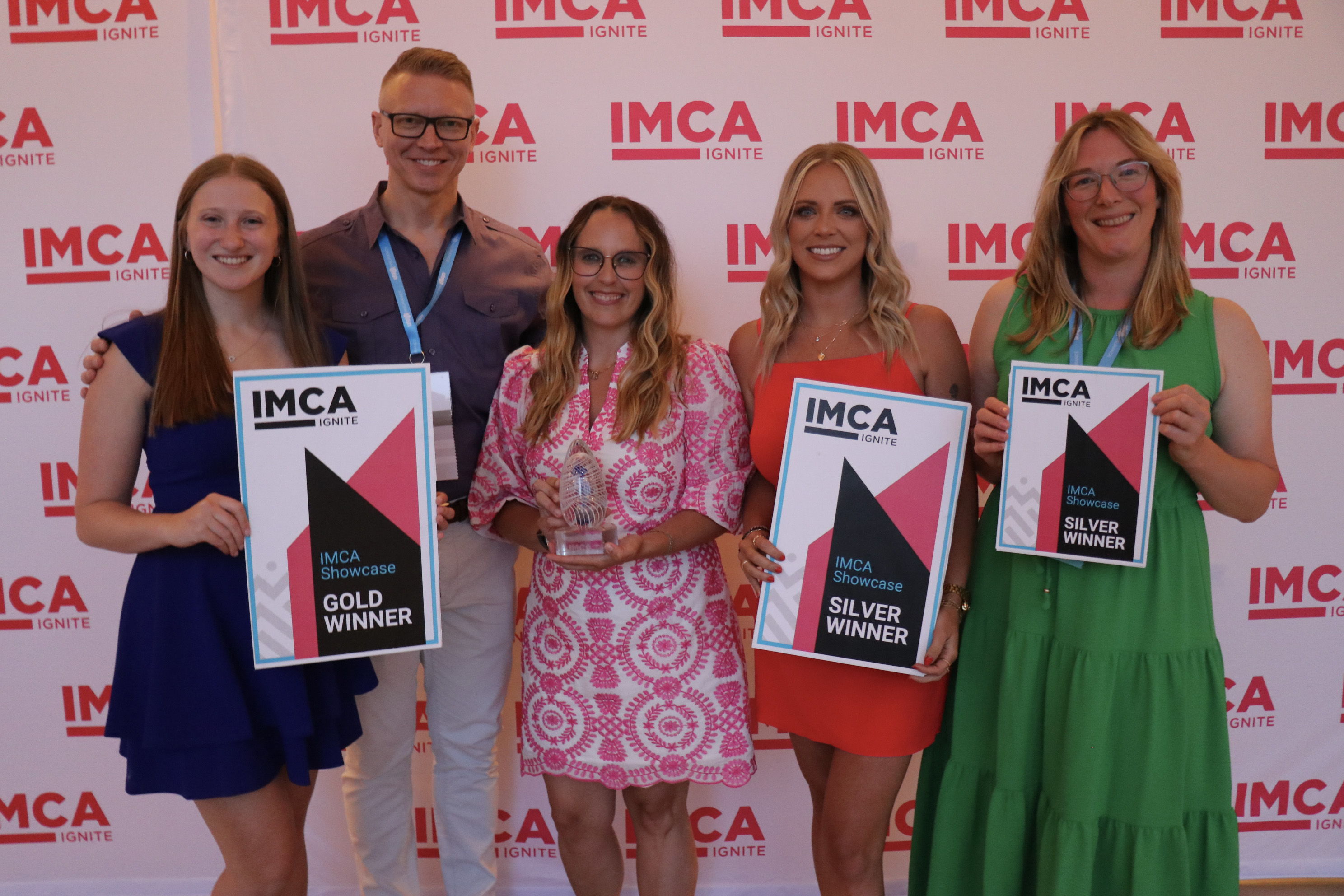 Five individuals smiling, holding awards.