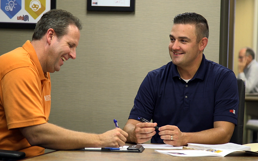 Careers-EmployeeBenefits-FinancialSecurity Two men talking at a conference room table