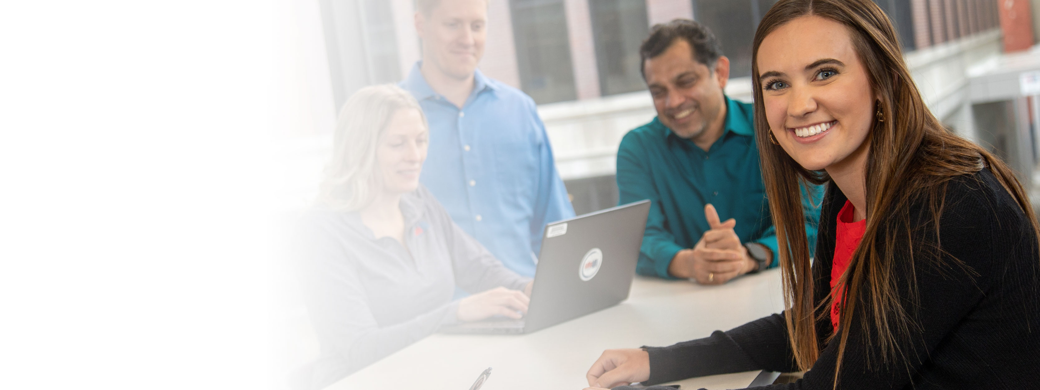 UFG employee smiling while working on laptop