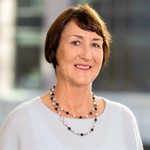 Professional woman in light blue sweater with short dark brown hair