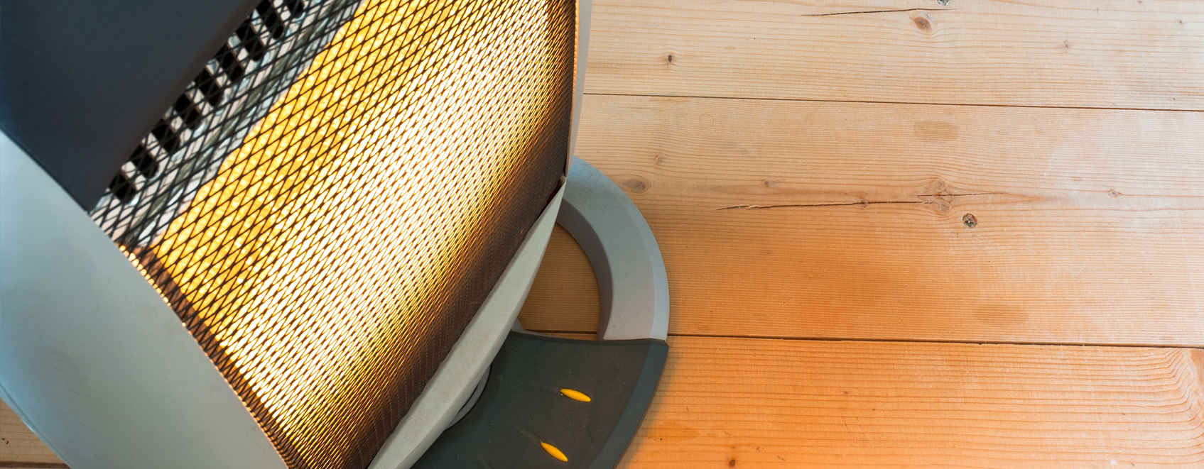 Space heater operating in room with wooden floor.