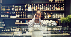 Small restaurant owner standing behind counter smiling