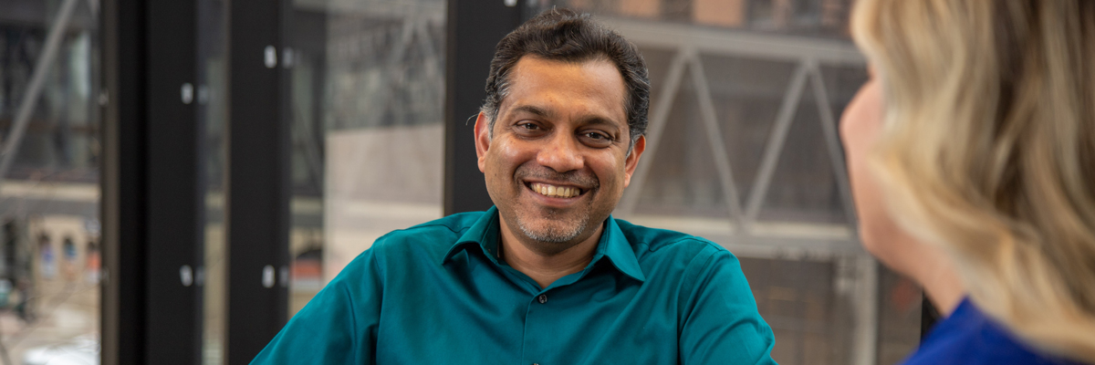 Person smiling in office hallway.
