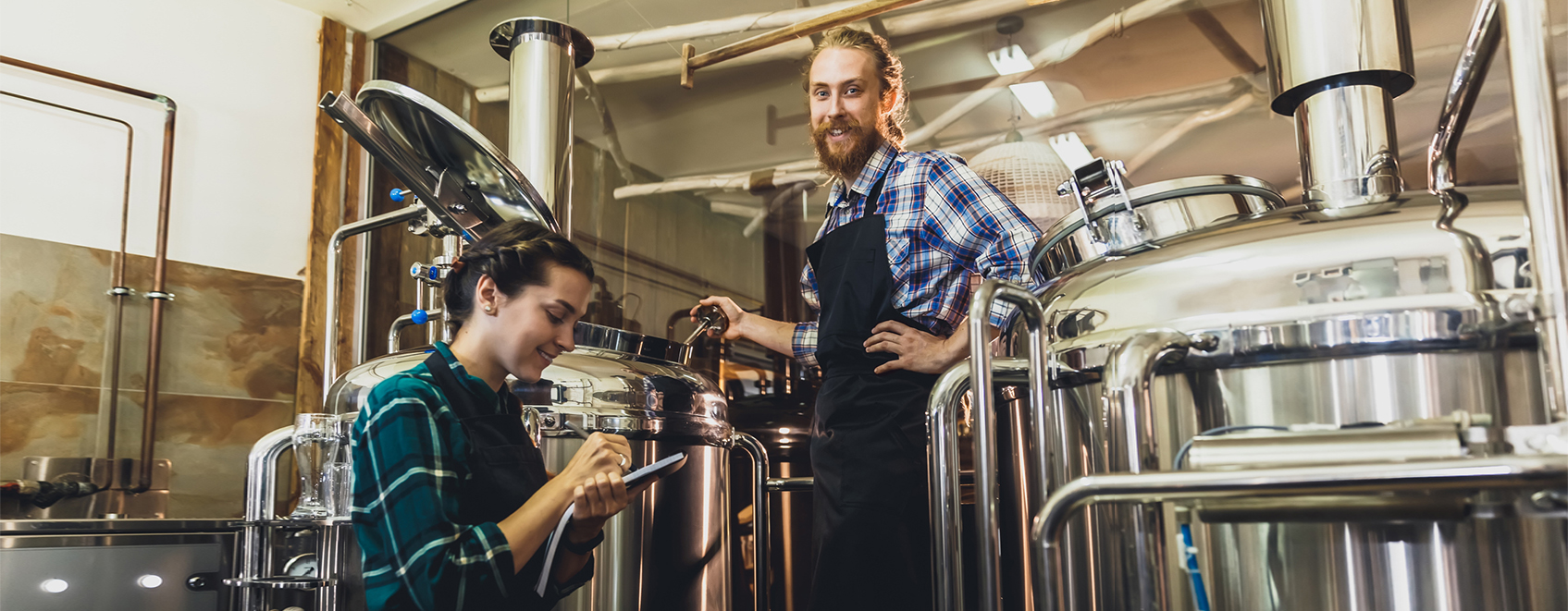 Brewery owners working with their equipment