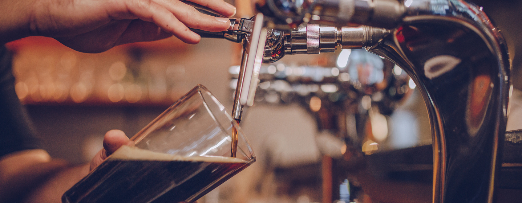 closeup of hand pouring beer from tap