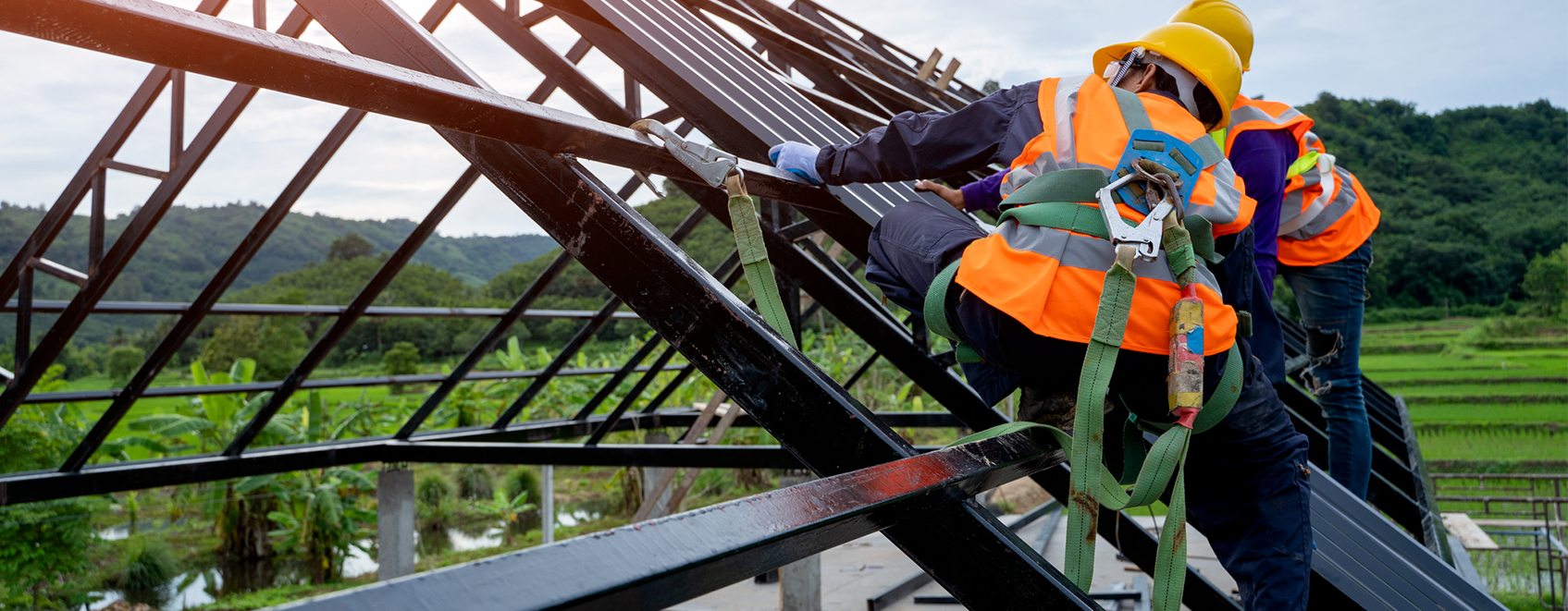 construction workers on roof, with safety harnesses on