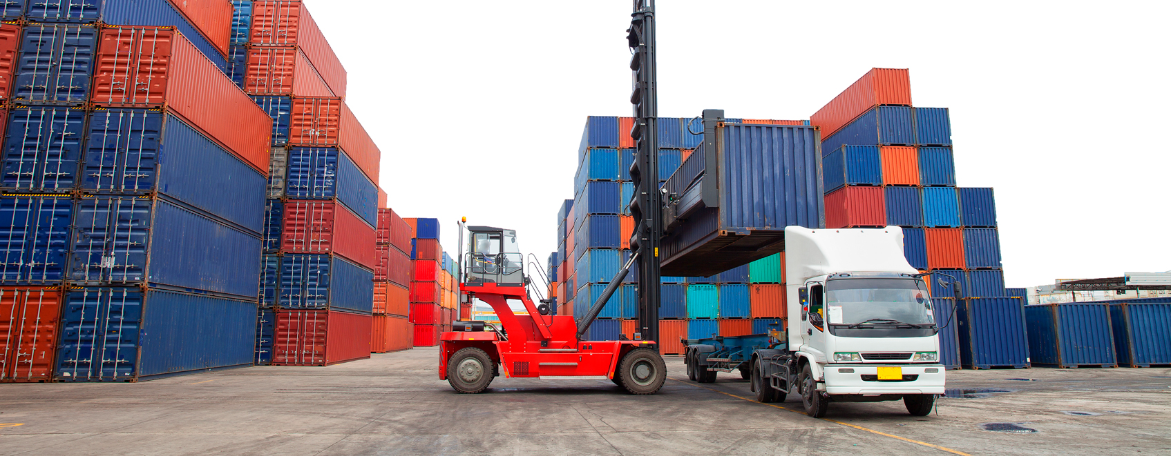 Truck in front of shipping containers. 