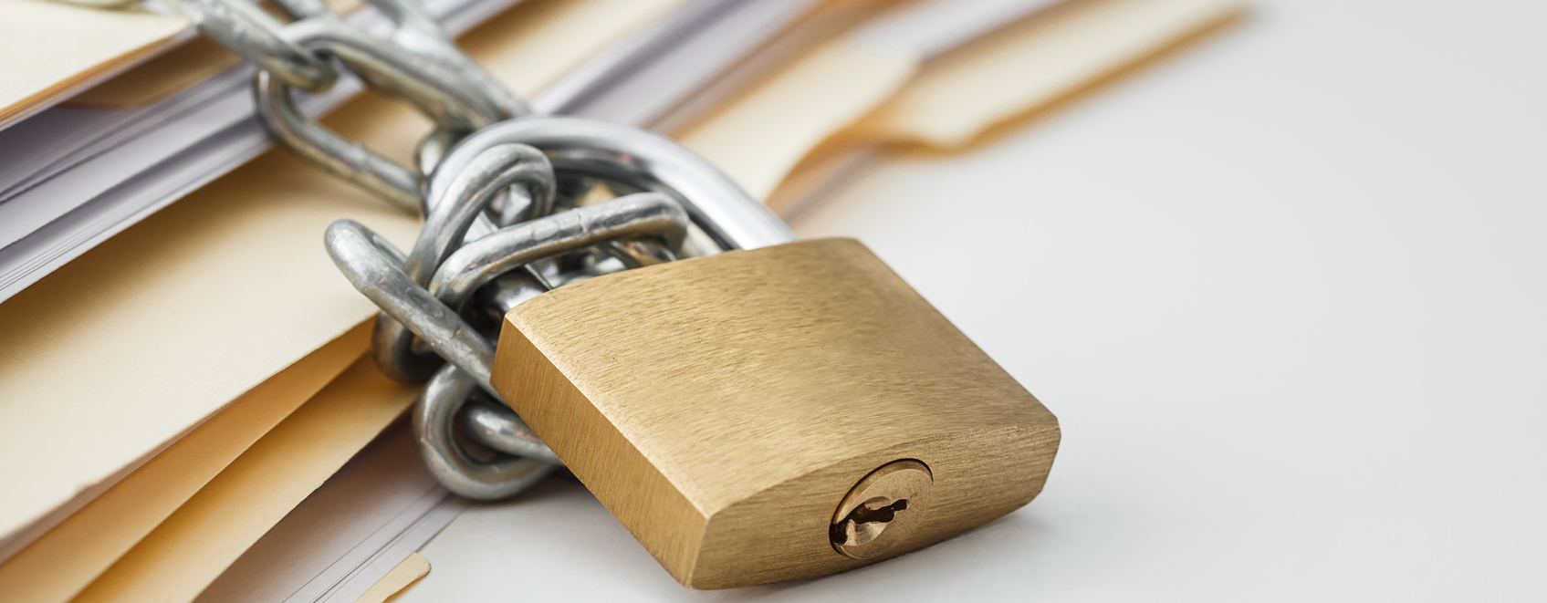 stack of manila folders, with padlock and chains on them