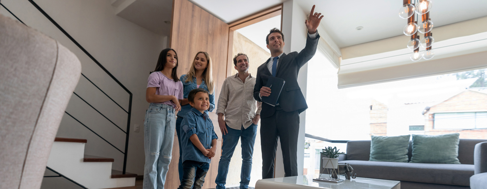 A real estate agent with business insurance showing a house to a family