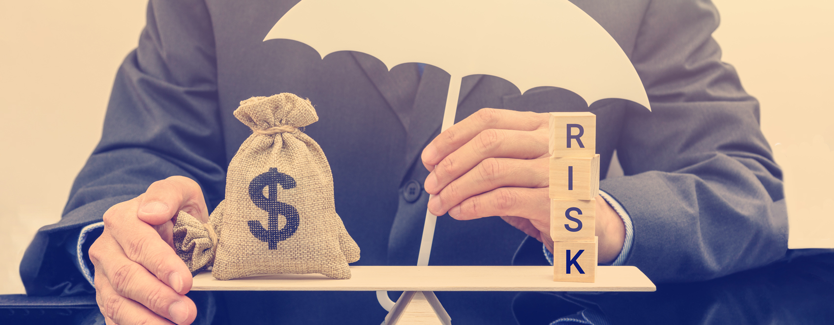 person's hands holding small umbrella, and weighing bag of money against blocks that say Risk