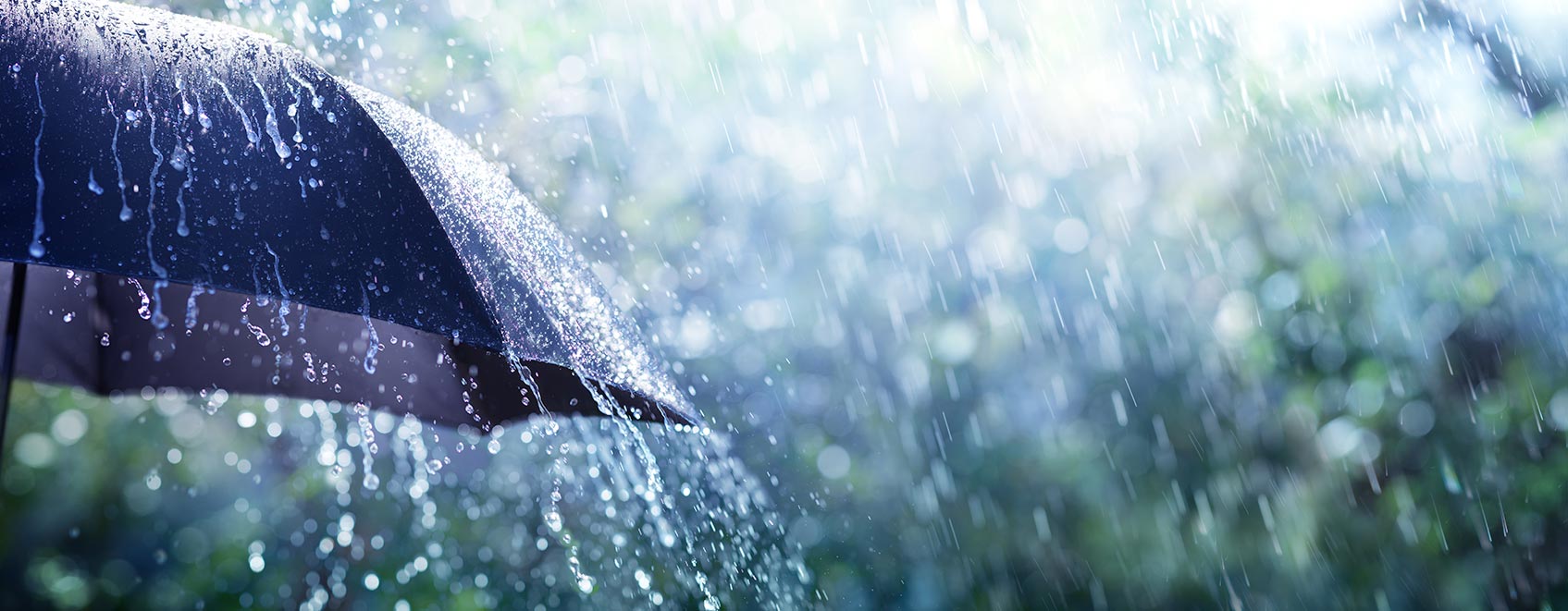 Closeup of umbrella, with rain pouring down on it