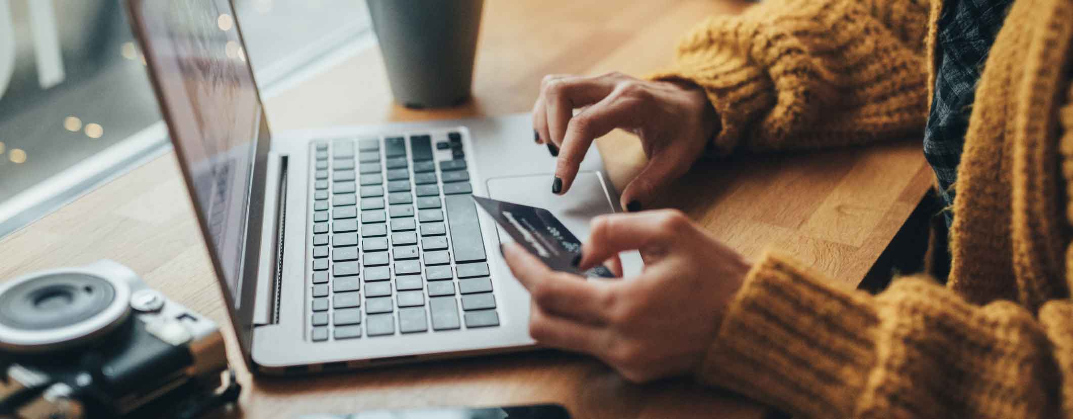 Person a laptop shopping online with credit card in hand.