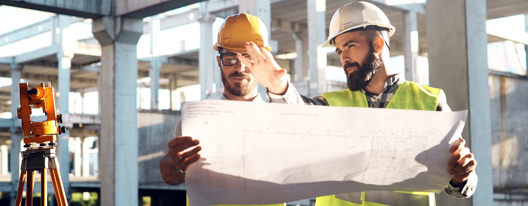 Construction leaders reviewing blueprints at jobsite