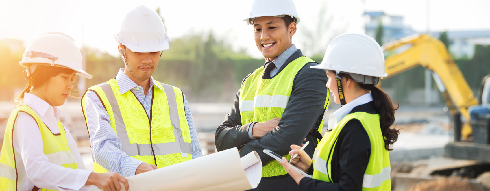 Diverse construction team at work site reviewing construction plans.