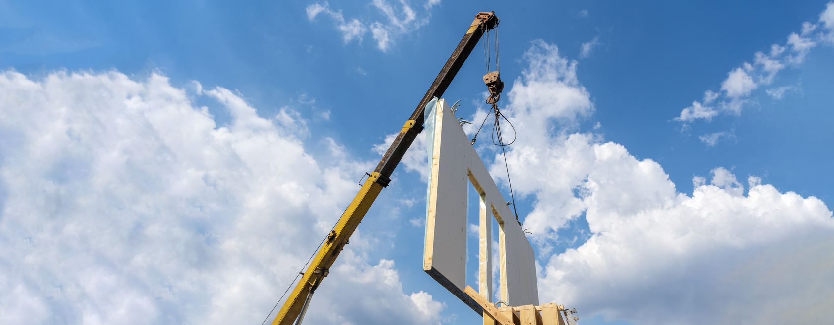 Crane moving walls at pre-fab construction facility